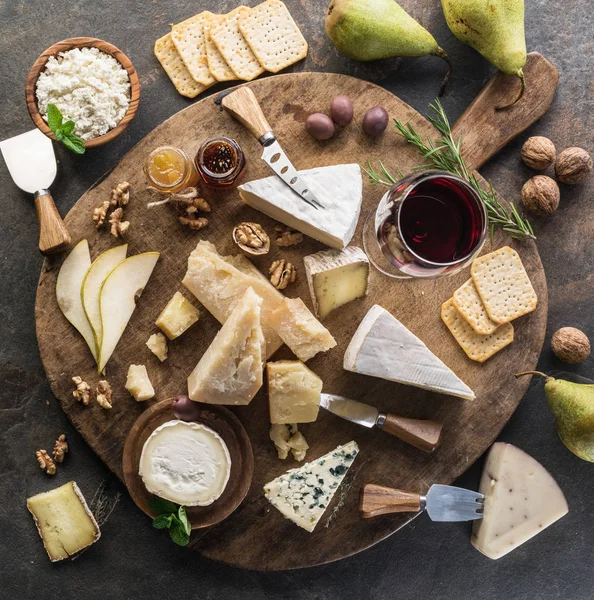 Käseplatte Mit Verschiedenen Käsesorten Früchten Nüssen Und Wein Auf Steingrund — kostenloses Stockfoto