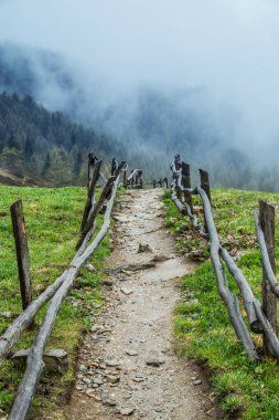 Dolomites Alps. Çit yolundaki dağ tepeleri. Arka plan bulutlara kaplı dağlar başında.