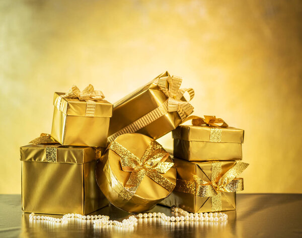 Golden gift boxes as a symbol of wishes and celebration. Golden blurred bokeh background.