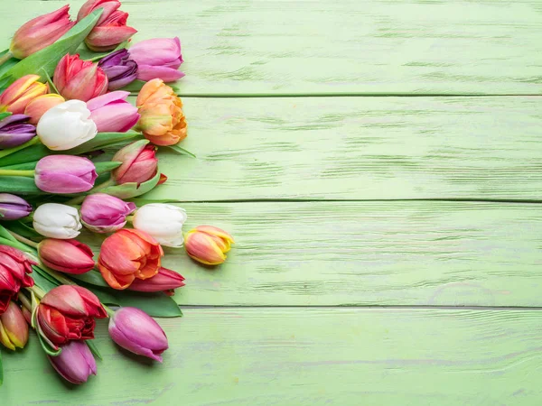 五颜六色的郁金香花束在绿色木质背景 顶部视图 — 图库照片