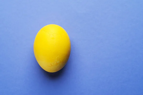 Stained in yellow Easter egg as an attribute of Easter celebrati — Stock Photo, Image