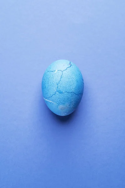 Mořená v modré velikonoční vajíčko na modrém pozadí. — Stock fotografie