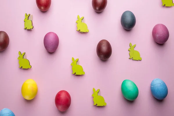 Красочные пасхальные яйца и деревянные пасхальные кролики в качестве атрибута E — стоковое фото
