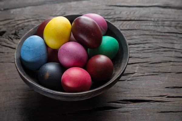 Colorful Easter eggs in bowl on wooden table. Attribute of Easte — Stock Photo, Image