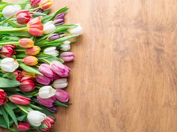 Bouquet coloré de tulipes sur fond en bois . — Photo