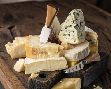 Assortment of different cheese types on wooden background. Chees
