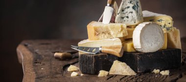 Assortment of different cheese types on wooden background. Chees clipart