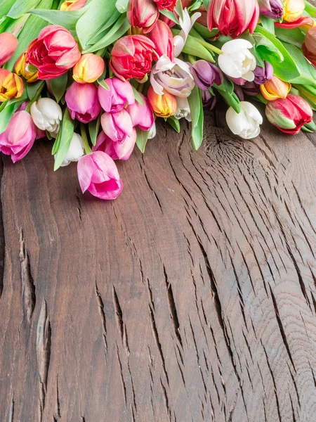 Bouquet colorato di tulipani su vecchio sfondo di legno . — Foto Stock