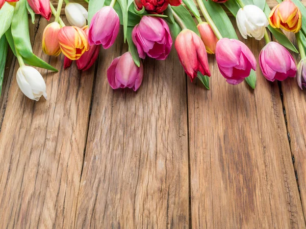 Bouquet colorato di tulipani su sfondo di legno . — Foto Stock