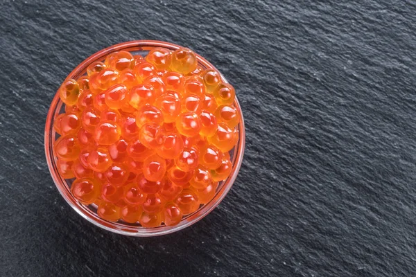 Roter Kaviar in der Schüssel auf grauem Graphithintergrund. Ansicht von oben. — Stockfoto