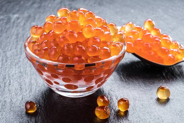 Red caviar in the bowl on gray graphite background. — Stock Photo, Image