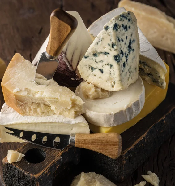 Surtido de diferentes tipos de queso sobre fondo de madera. Chees —  Fotos de Stock