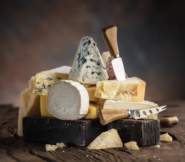 Surtido de diferentes tipos de queso sobre fondo de madera. Chees — Foto de Stock