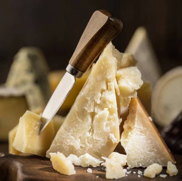 Piece of Parmesan cheese  on the wooden board. Assortment of dif — Stock Photo, Image