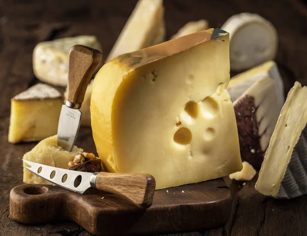 Pedazo de leche de vaca queso Maasdam sobre tabla de madera. Gama de la —  Fotos de Stock