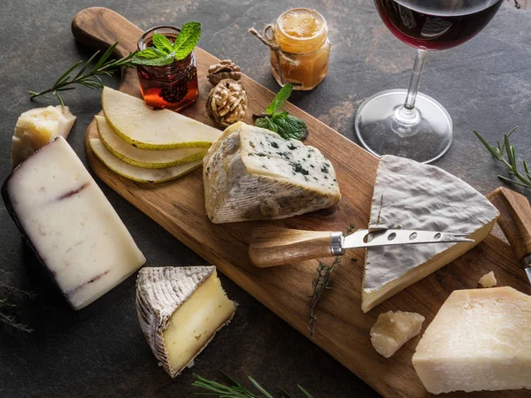 Piatto di formaggio con formaggi biologici, frutta, noci e vino a st — Foto Stock