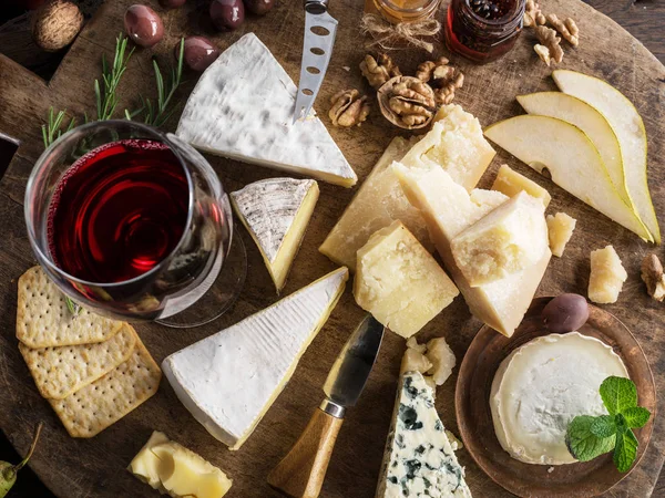 Bandeja de queso con quesos ecológicos, frutas, frutos secos y vino en wo — Foto de Stock