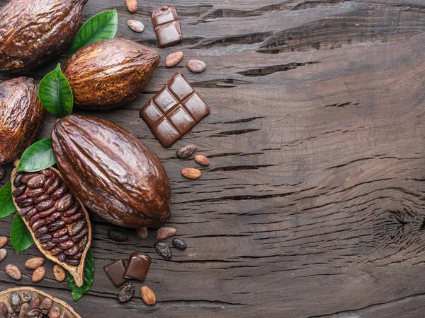 Какао-стручок, какао-боби і шоколад на дерев'яному столі. Топ-ві — стокове фото
