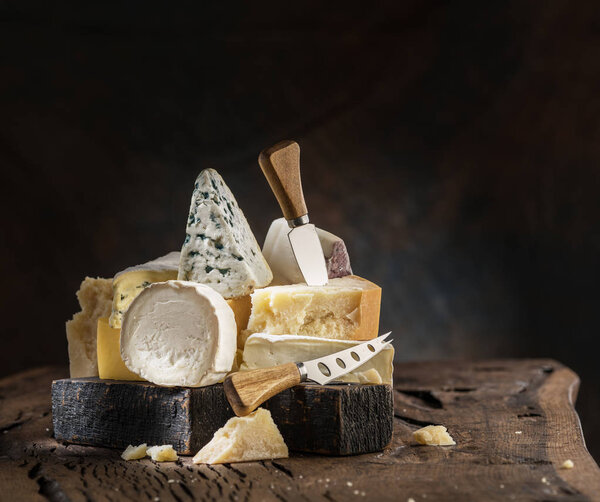 Assortment of different cheese types on wooden background. Chees