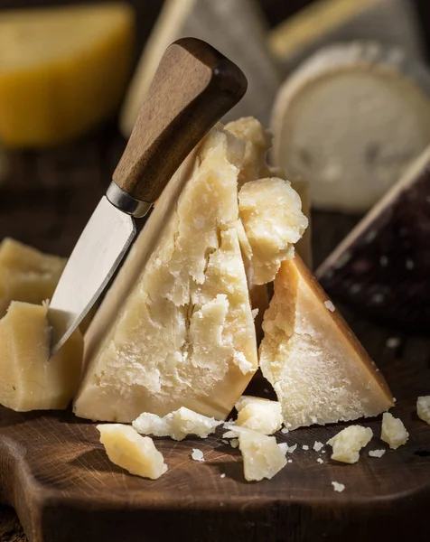 Stukje Parmezaanse kaas op het houten bord. Assortiment van dif — Stockfoto