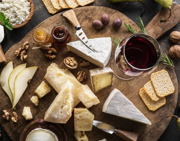 Kaasschotel met verschillende kazen, fruit, noten en wijn op — Stockfoto