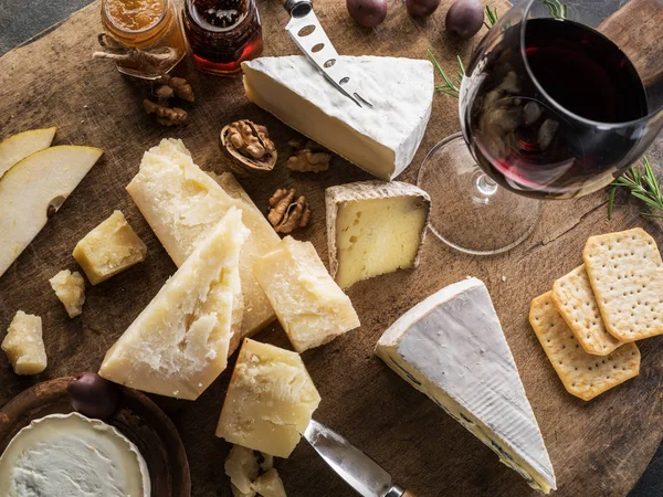 Piatto di formaggio con diversi formaggi, frutta, noci e vino su — Foto Stock