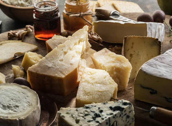 Cheese platter with organic cheeses, fruits, nuts and wine on wo — Stock Photo, Image