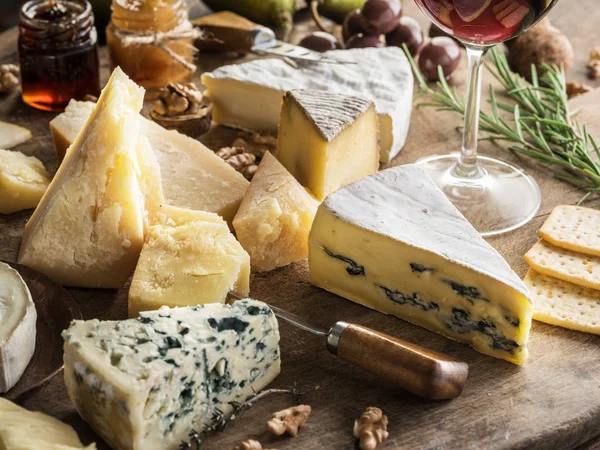 Bandeja de queso con quesos ecológicos, frutas, frutos secos y vino en wo — Foto de Stock