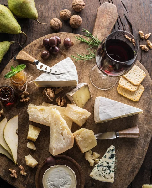 Prato de queijo com queijos orgânicos, frutas, nozes e vinho em wo — Fotografia de Stock