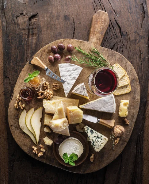 Ostbricka med ekologiska ostar, frukter, nötter och vin på wo — Stockfoto