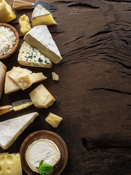 Assortment of different cheese types on wooden background. Top v — Stock Photo, Image