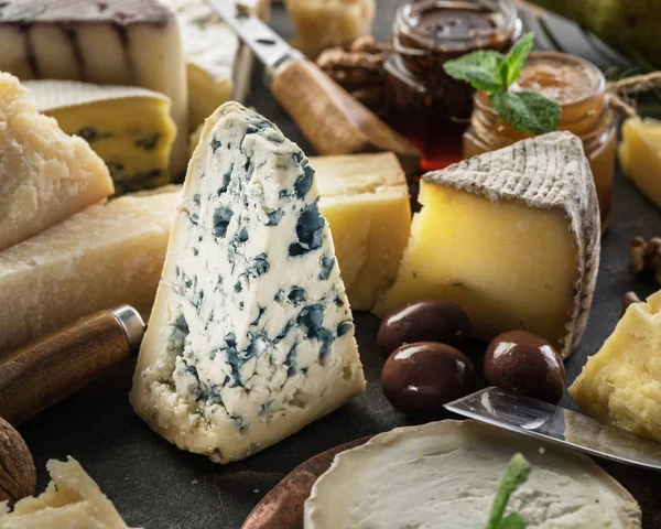 Assortment of different cheeses with olives and jams. Food backg — Stock Photo, Image