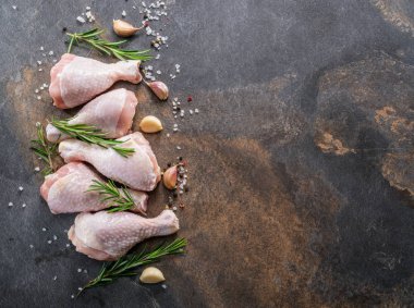 Baharatlar ve tuz yemek pişirmek için hazır tavuk budu. 