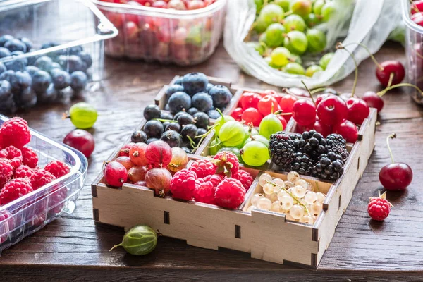 Colorful berries in wooden box on the table. — Stock Photo, Image