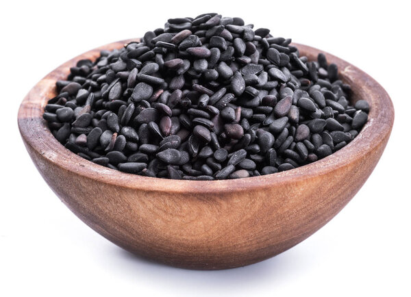 Black sesame seeds in the wooden bowl on white background. 