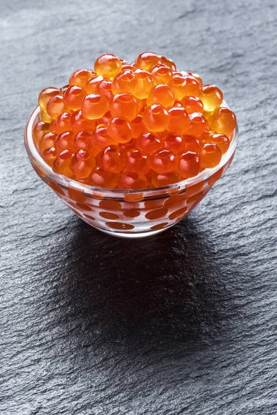 Red caviar in the bowl on gray graphite background. — Stock Photo, Image