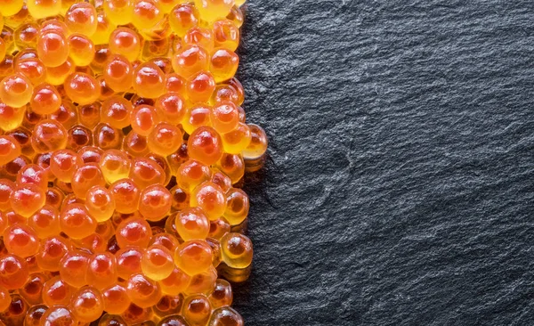 Red caviar on gray graphite background. Top view. — Stock Photo, Image