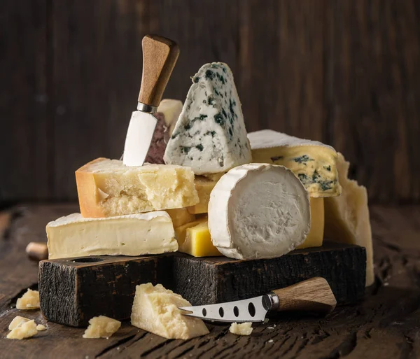 Surtido de diferentes tipos de queso sobre fondo de madera. Chees —  Fotos de Stock