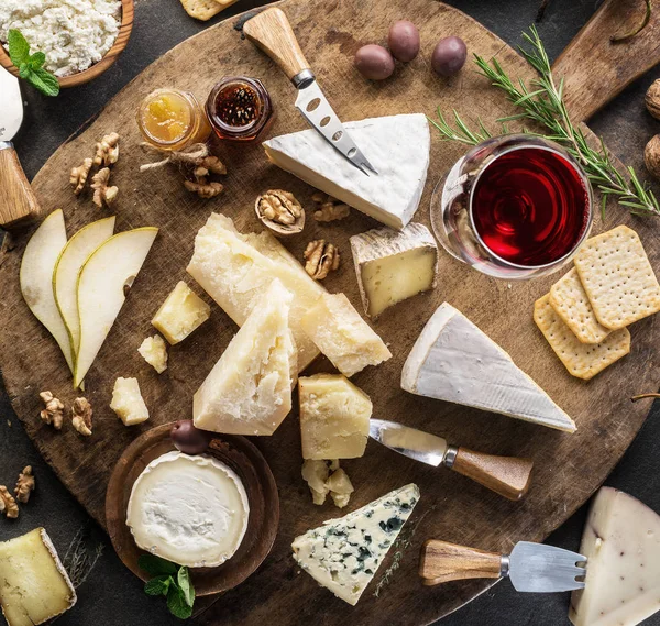 Piatto di formaggio con diversi formaggi, frutta, noci e vino su — Foto Stock