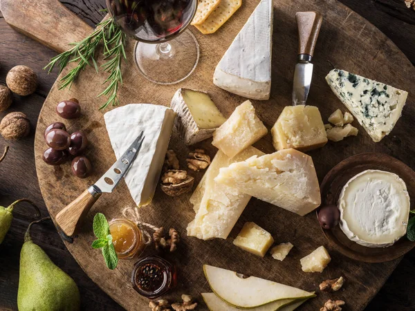 Bandeja de queso con quesos ecológicos, frutas, frutos secos y vino en wo —  Fotos de Stock