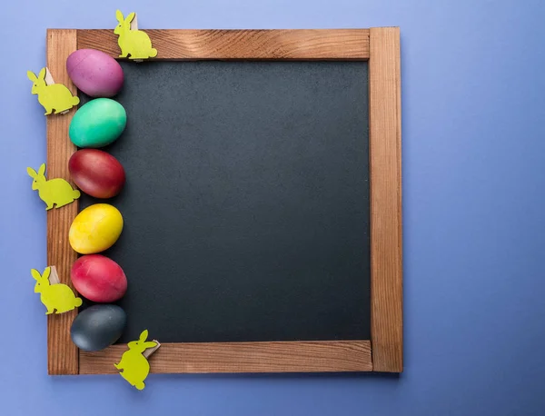칠판 그리고 그것의 주위에 다채로운 부활절 달걀입니다. 위에서 보기. — 스톡 사진