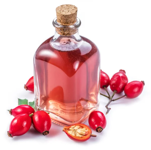 Rose-hips and rosehip seed oil on the white background. — Stock Photo, Image