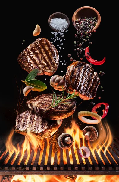 Gotowane mięsa wołowego, którą steki z warzywami i przyprawami latać nad blazi — Zdjęcie stockowe