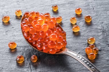 Gümüş kaşık gri grafit arka plan üzerinde kırmızı havyar. Makro pi