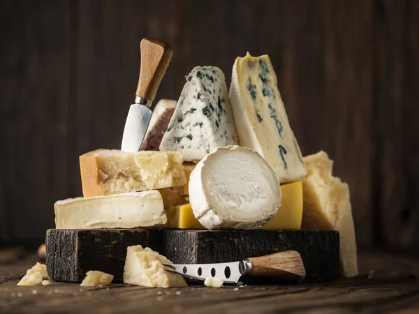Surtido de diferentes tipos de queso sobre fondo de madera. Chees — Foto de Stock