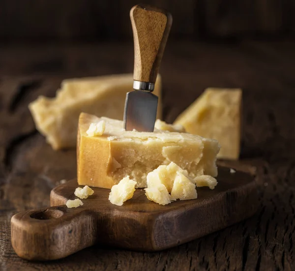 Stukje Parmezaanse kaas en Kaasmes op het houten bord. D — Stockfoto