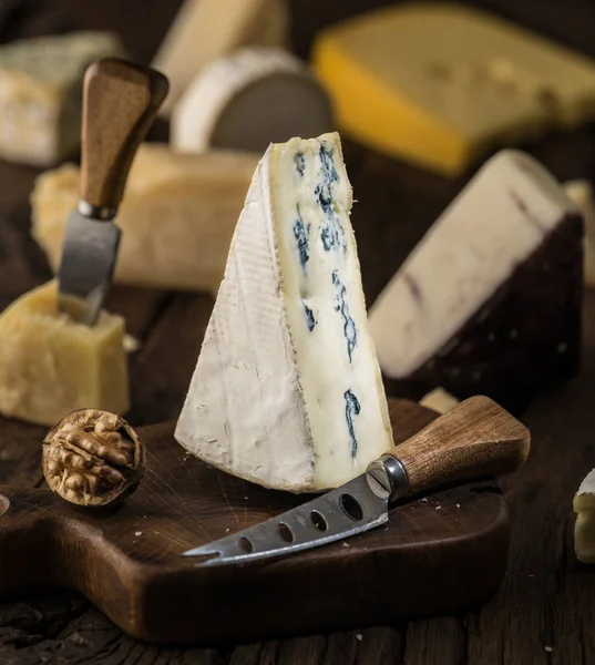 Segment of blue cheese or Cambozola cheese on wooden board. Diff — Stock Photo, Image