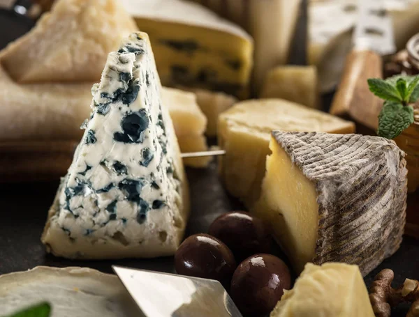 Segmento de queijo de molde azul com azeitonas e variedade de queijos em — Fotografia de Stock