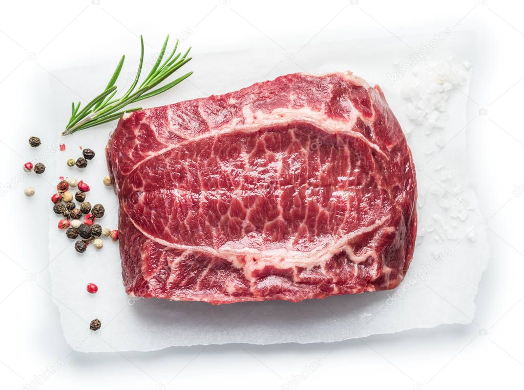 The top blade steak or beef steak with herbs and spices on white
