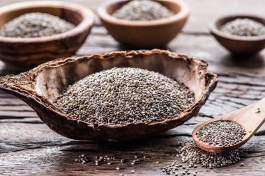 Eski ahşap masada farklı yemeklerle Chia tohumları. 